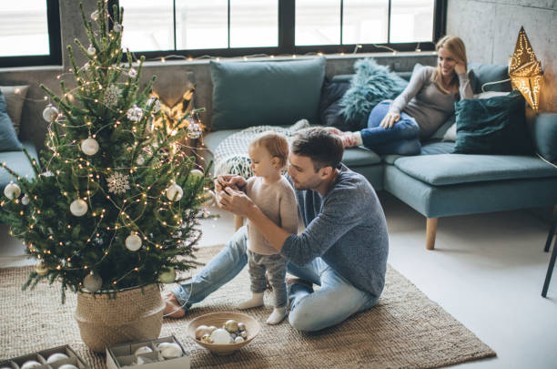 Father and daughter decorate a Christmas tree | Carpet Mart